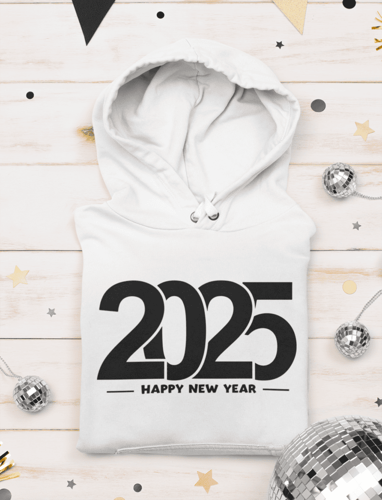 A white hoodie displaying a bold '2025 Happy New Year' design, styled against a light wooden background with disco balls and golden stars.